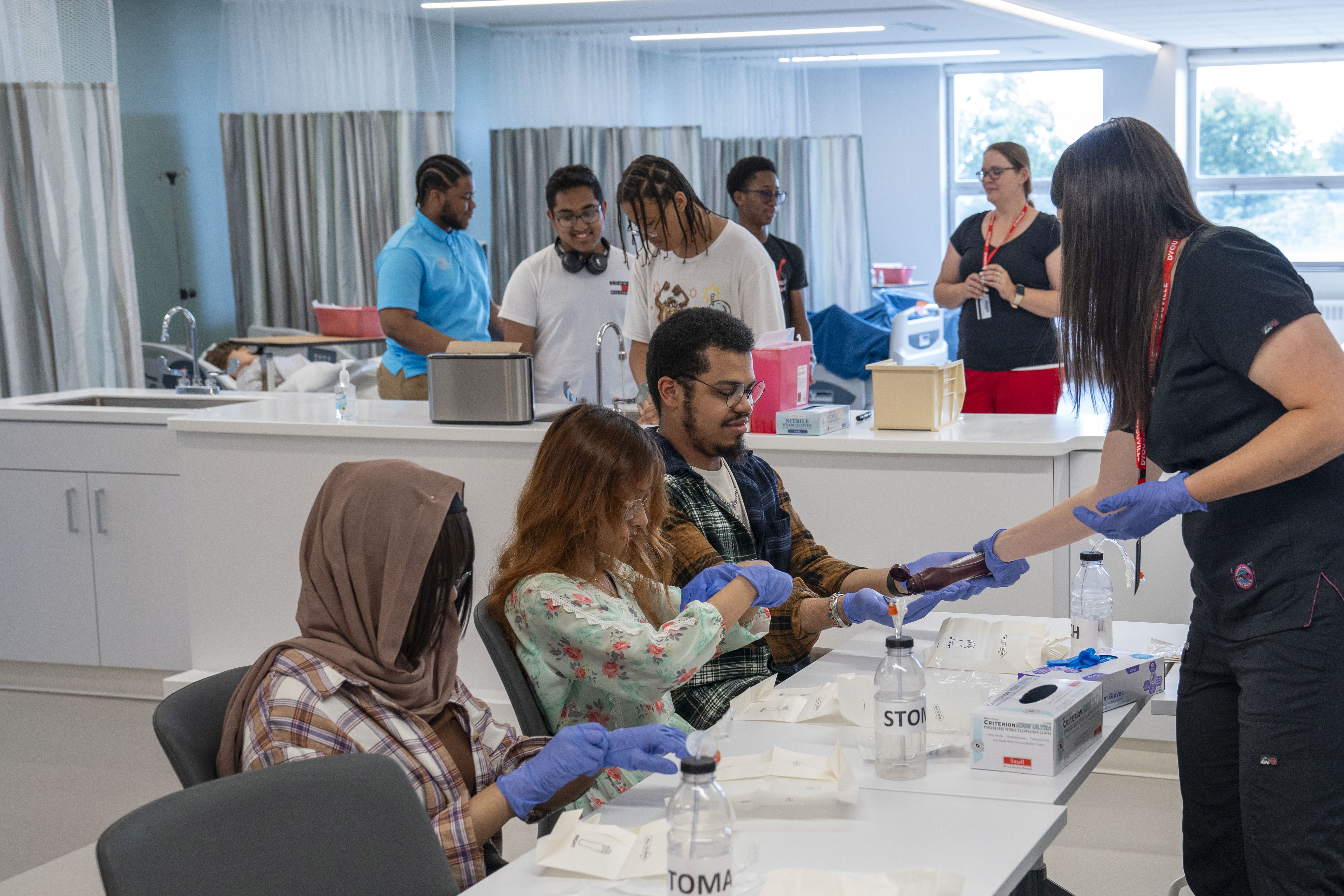 students put on medical gloves at a table