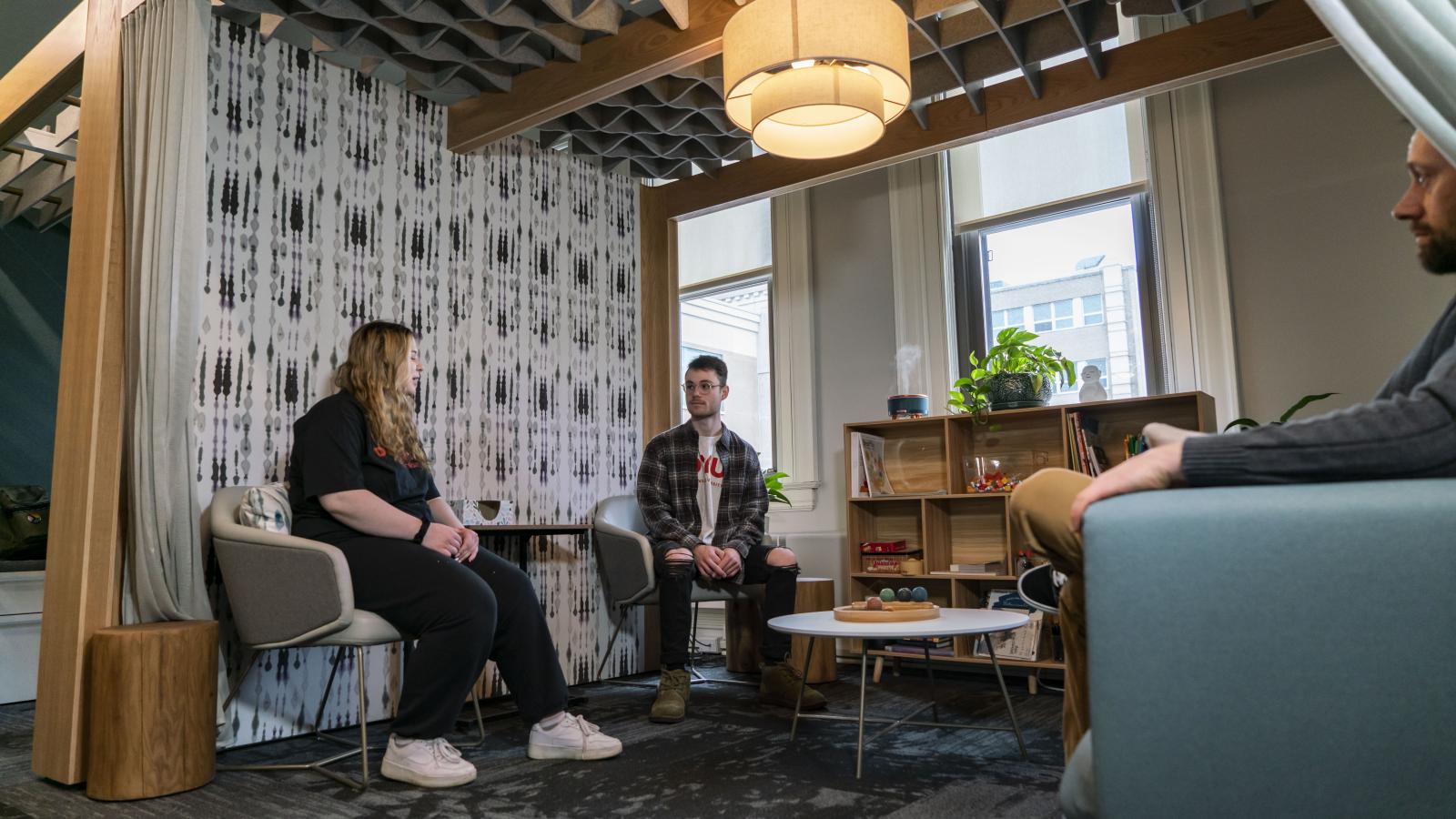 Two students sit next to each other talking. 