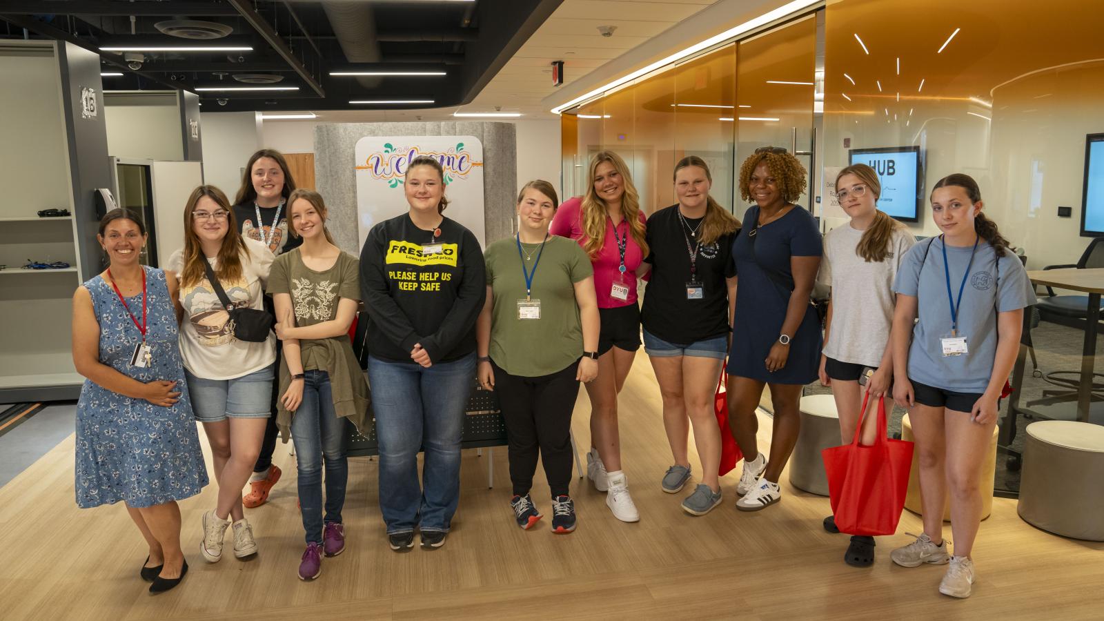 a group of students stand smiling inside the Health Professions Hub simulation center