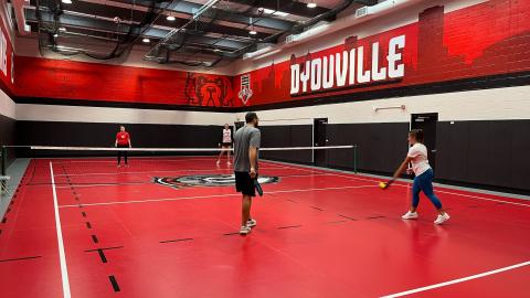 four people play doubles pickleball inside the auxiliary gym inside the D'Youville University College Center