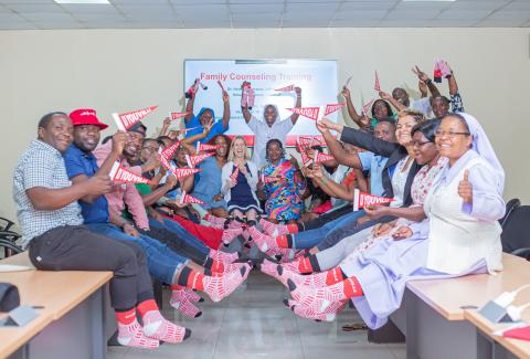 a group of people wearing D'Youville branded socks and waving D'Youville banners