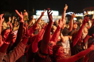 A crowd of people with their hands in the air