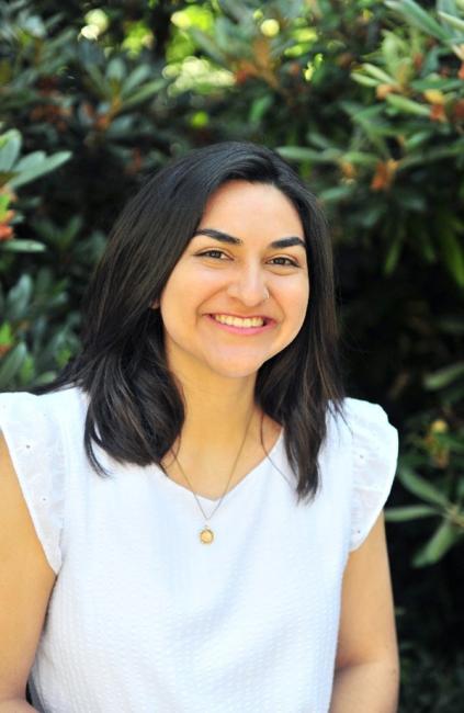 woman with black hair smiles at the camera