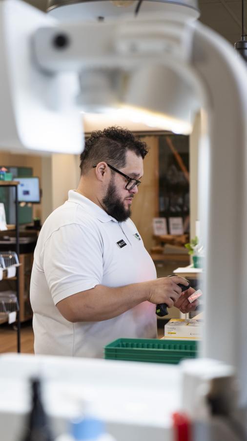 Pharmacist scans a barcode off of a pill bottle